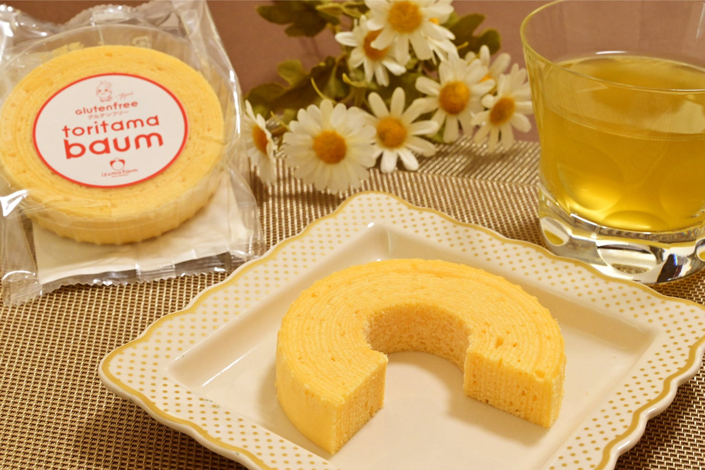 陶器の皿の上のりんご味の米粉バウムクーヘンと緑茶