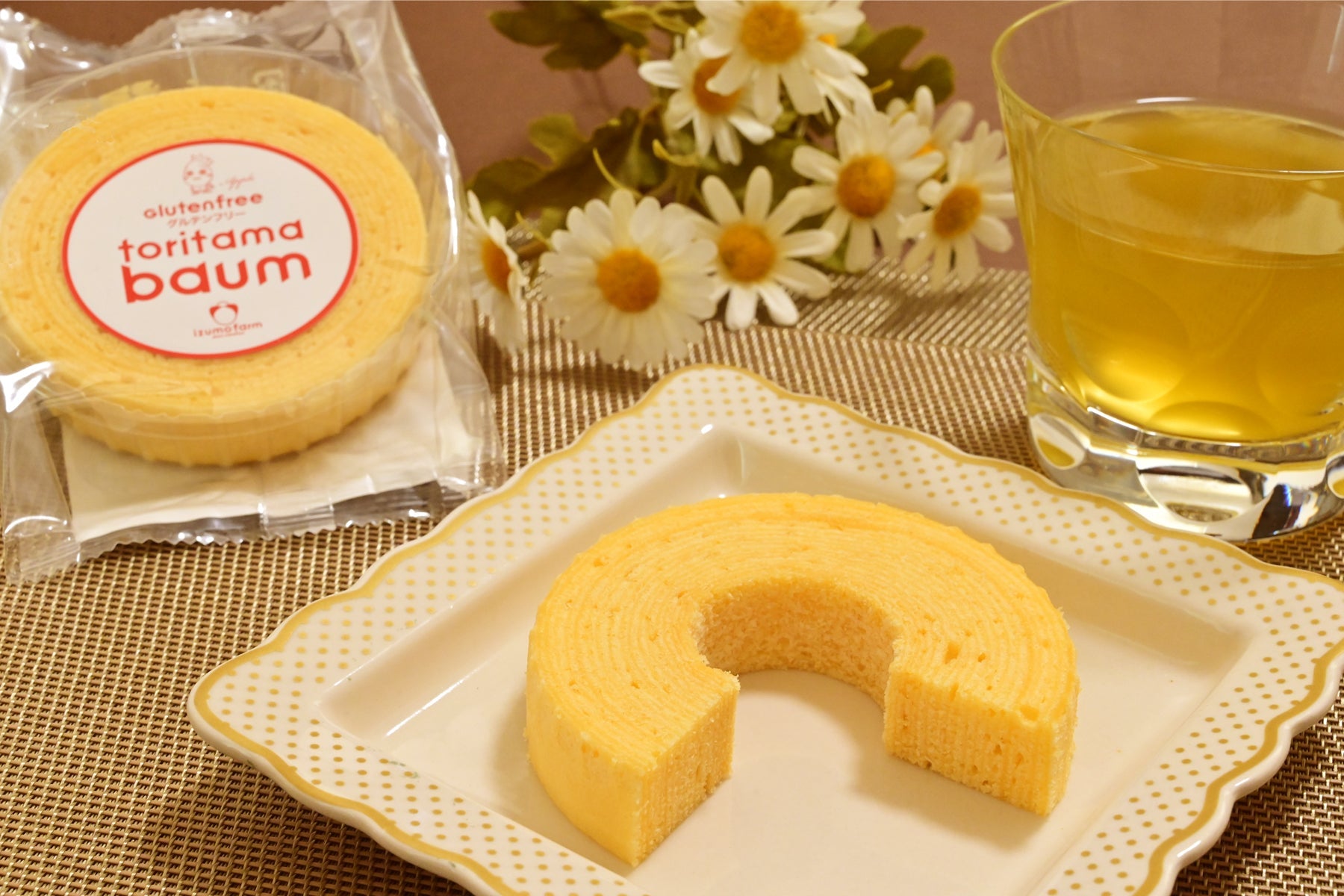 陶器の皿の上のりんご味の米粉バウムクーヘンと緑茶