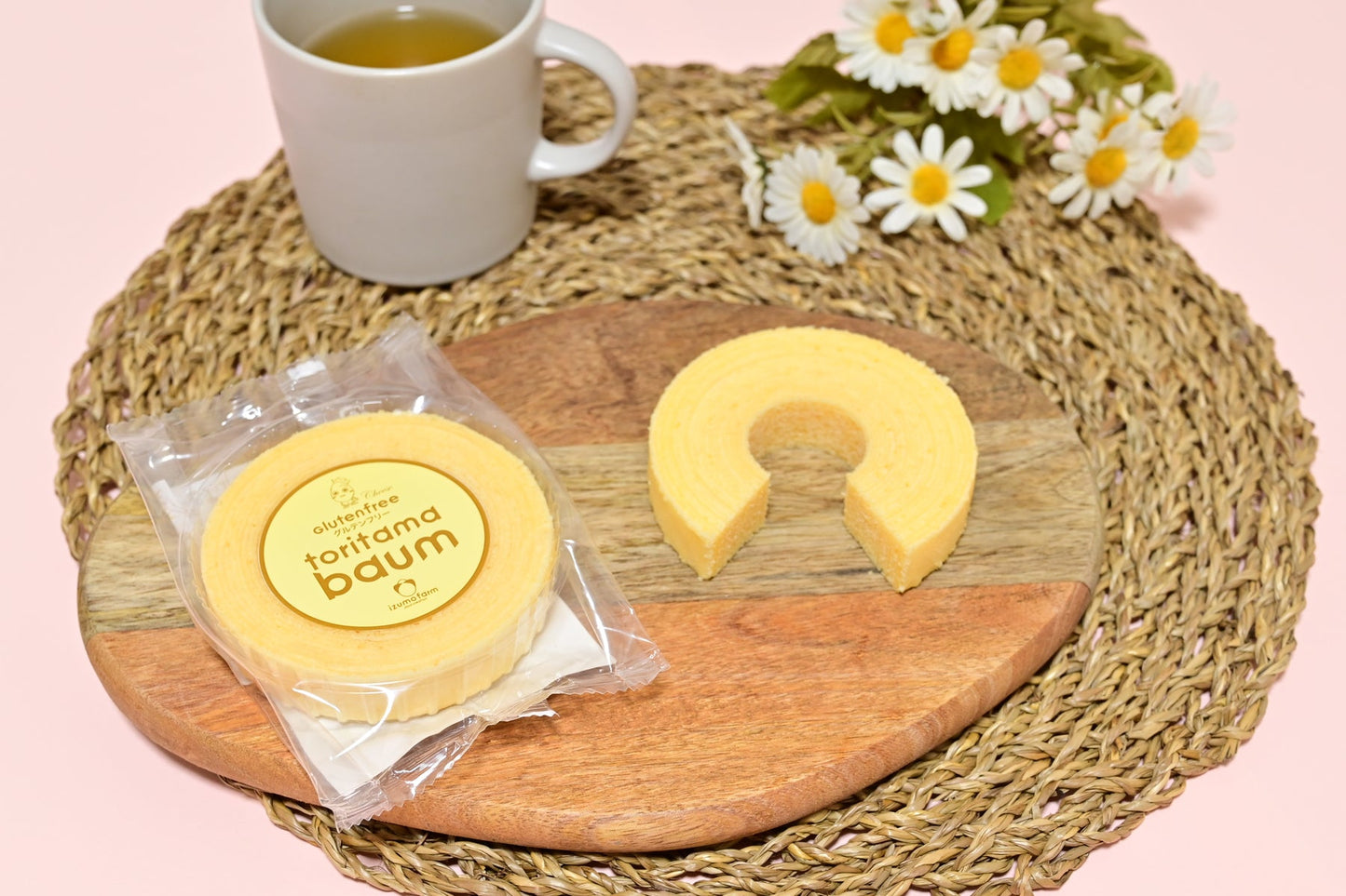 木製の皿に盛られたチーズ味の米粉バウムクーヘンとお茶