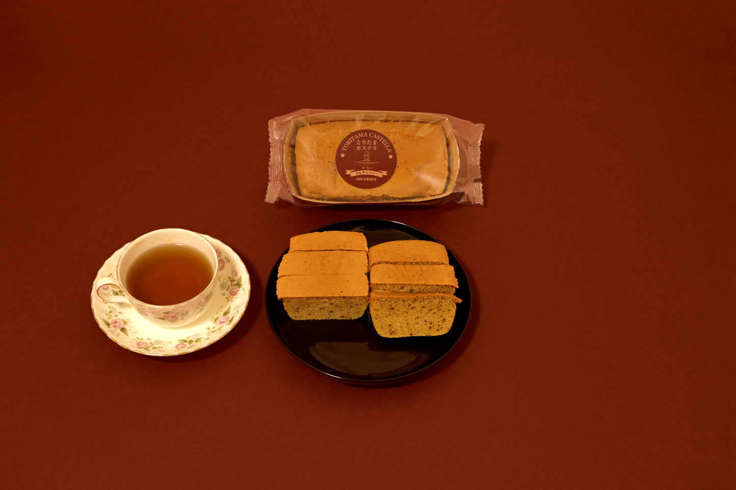 陶器の皿に盛られたコーヒー味のカステラと紅茶