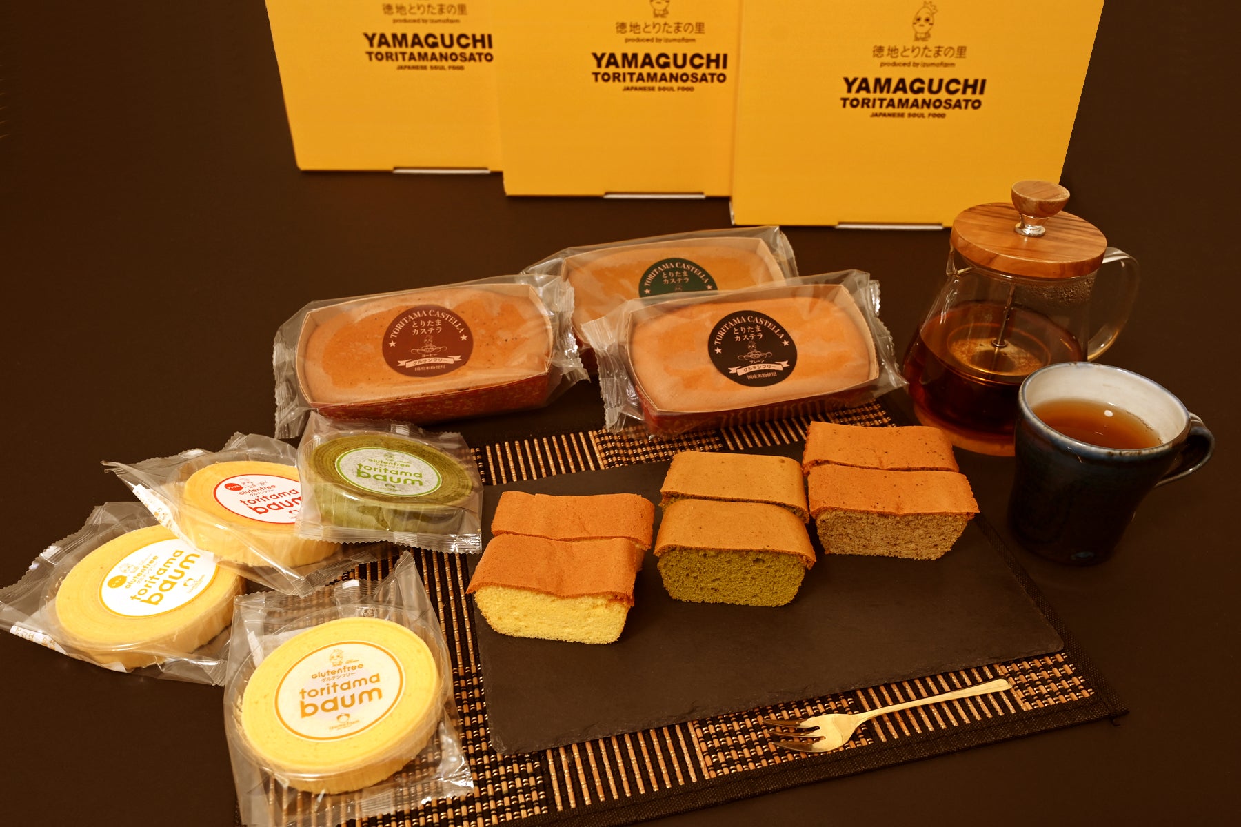 ギフトボックスの前に並ぶバウムクーヘンとカステラ