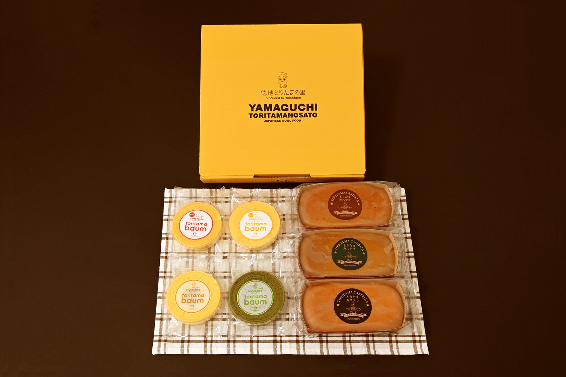 テーブルクロスの上に並んだ米粉バウムクーヘンと米粉カステラのギフトセット