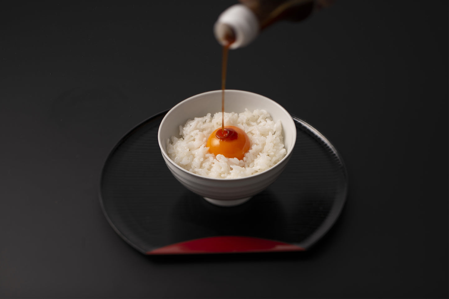 たまごかけごはんに醤油を垂らす様子