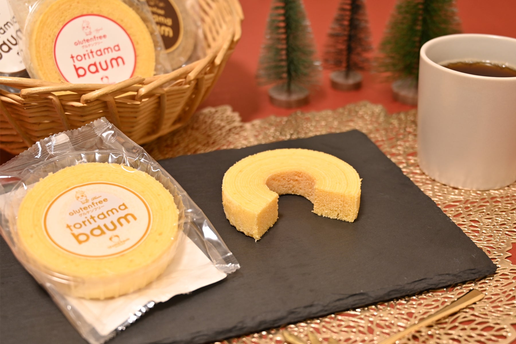 石の皿に並んだ米粉のバウムクーヘンとバスケットに入ったいくつかのお菓子